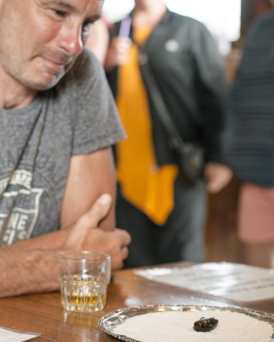 A man looks at his cocktail and a mummified toe