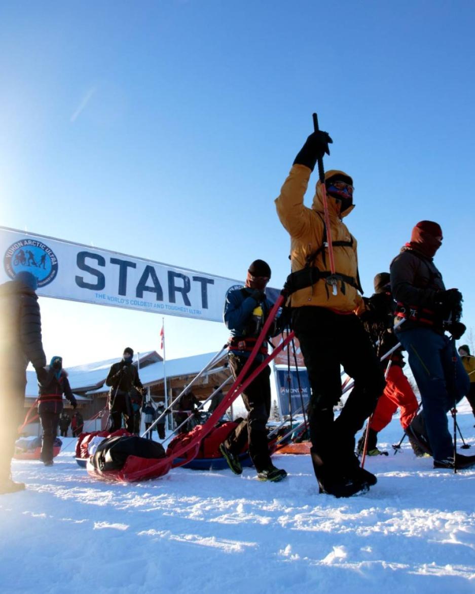 Yukon Arctic Ultra start line is lit up by a bright, frosty blue sky.