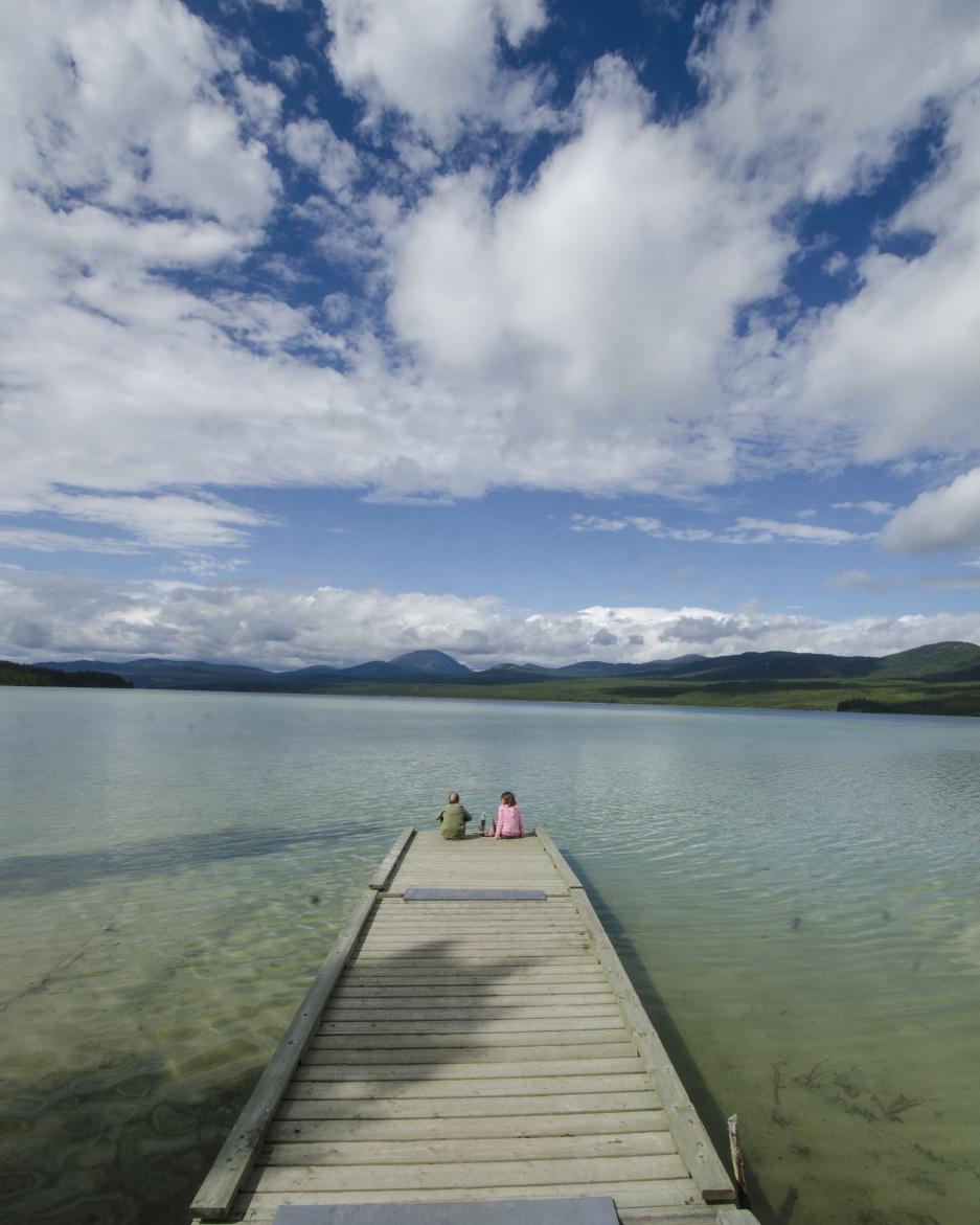Two children sit on a dock at Squanga Lake Campground