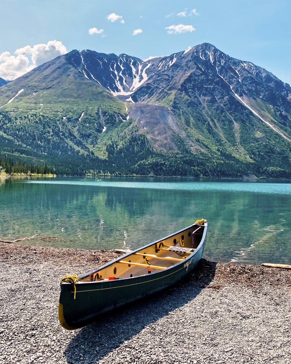 A canoe sits on the short of Kathleen Lake