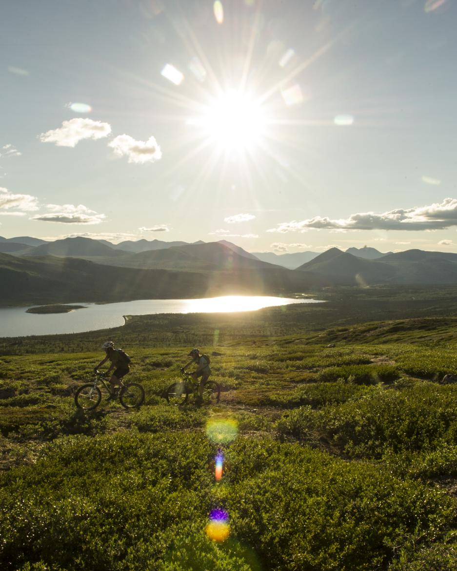 Two mountain bikers ride Mount McIntyre overlooking Fish Lake