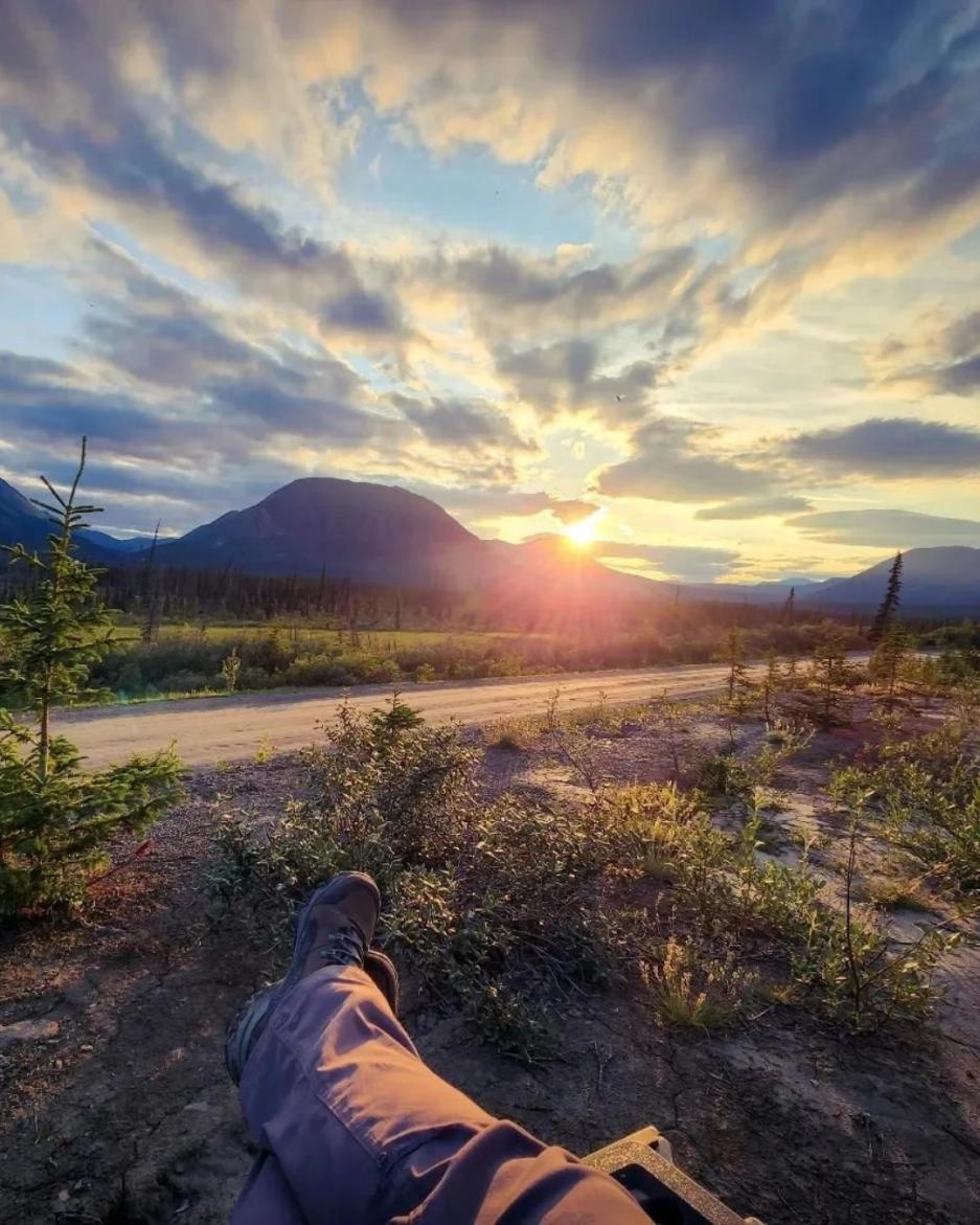 A person relaxes looking out at mountains