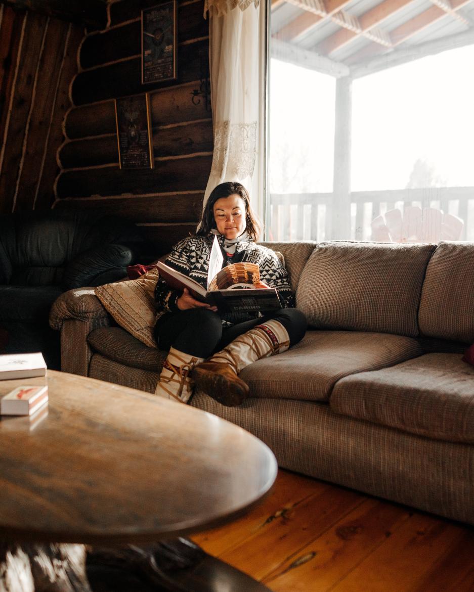 A woman relaxes in a cozy Yukon cabin
