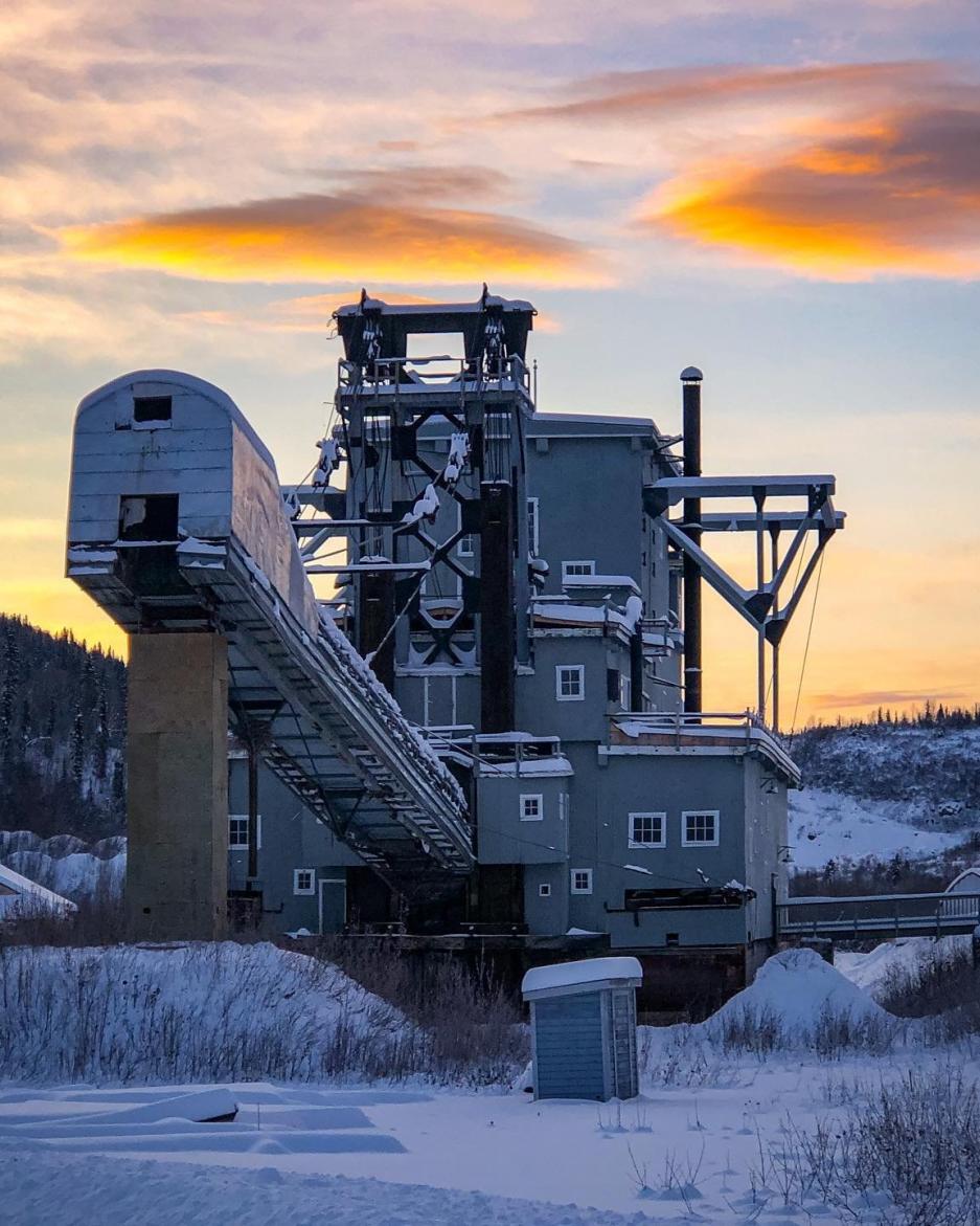 mining dredge under a winter sky and blanket of snow