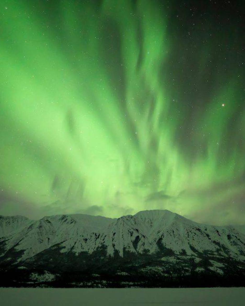 Green aurora over mountain