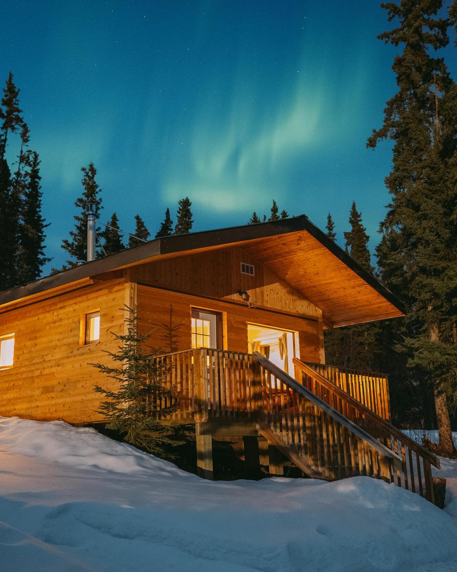 northern lights above a log cabin