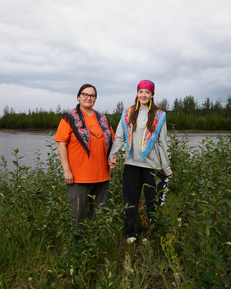 A mother and daughter stand on the old town site near Ross River.
