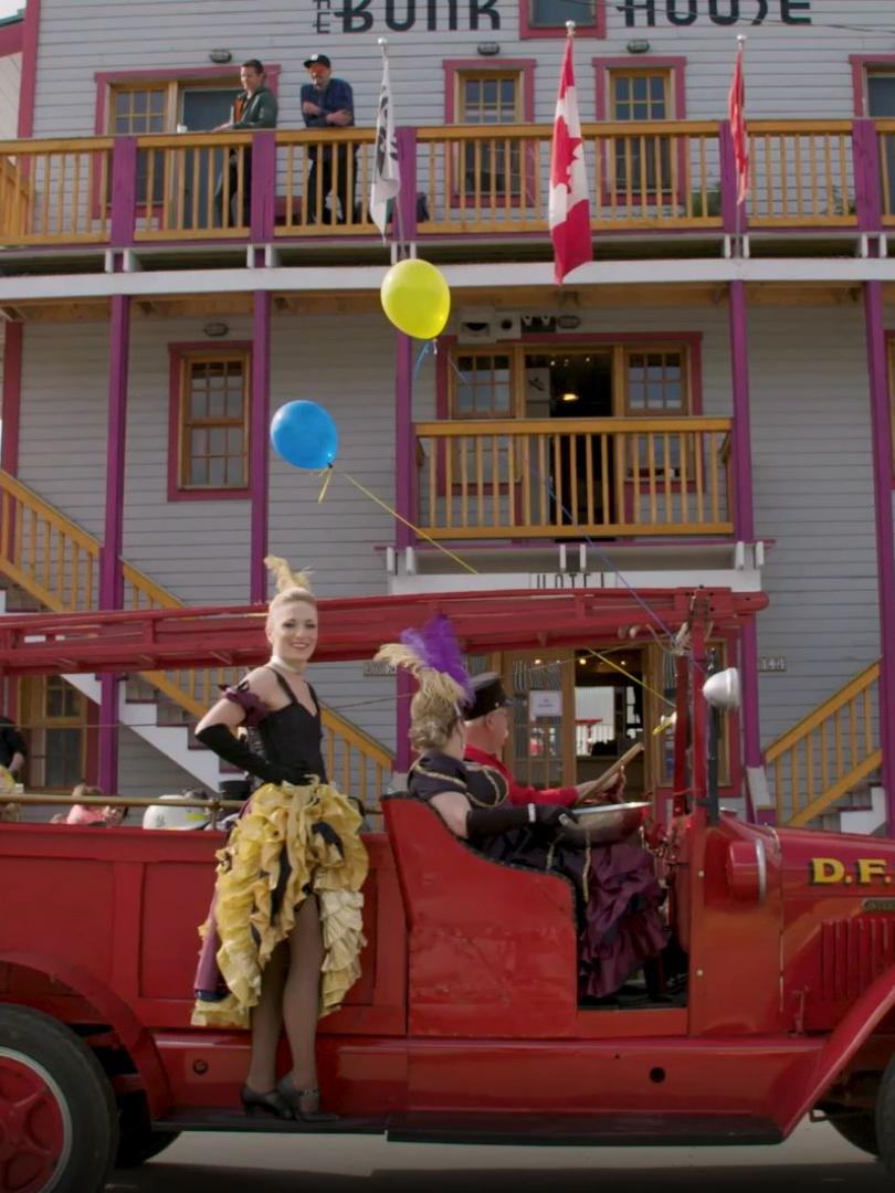 Can Can gilrs on a vintage truck in front of a Dawson City hotel