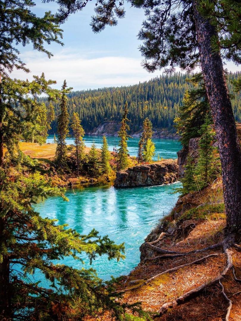 Teal water surrounds cliffs of an old canyon
