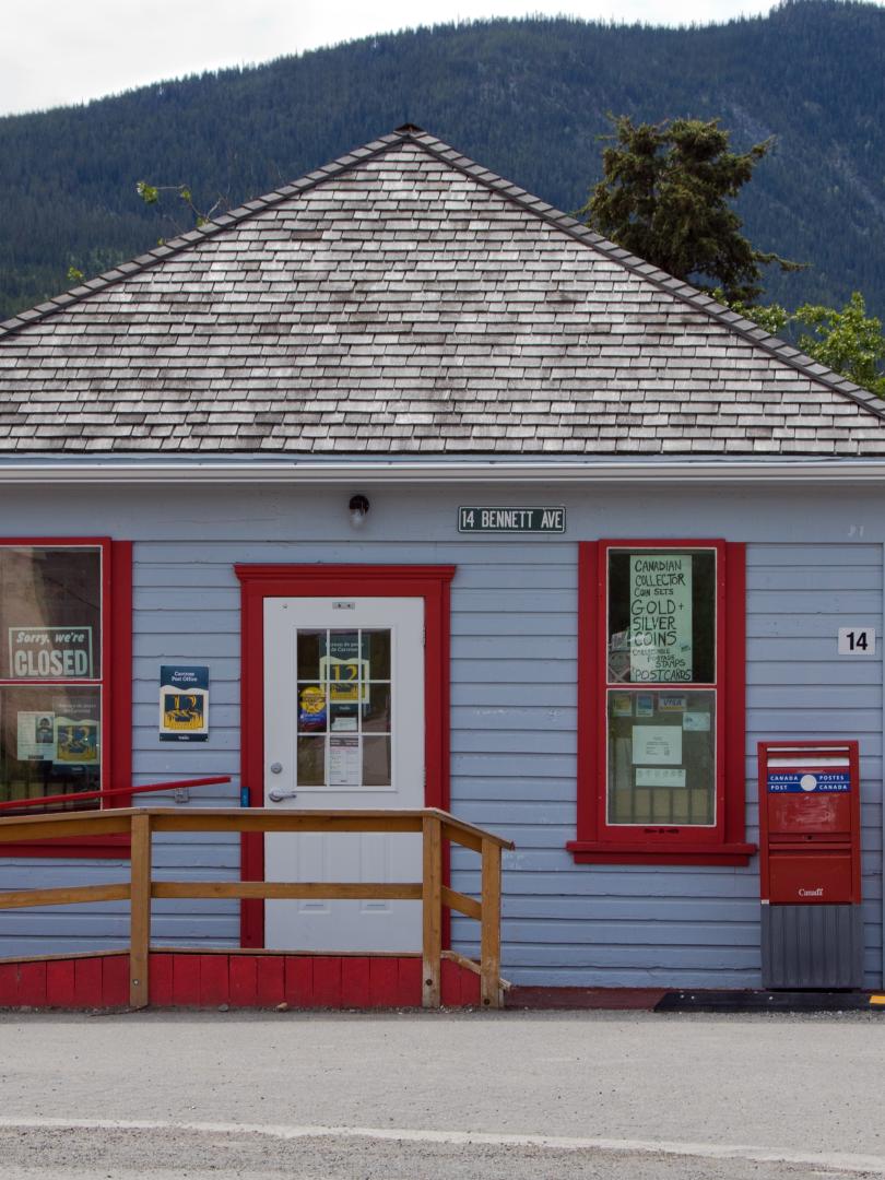 A small blue building with red trim around the doors and windows