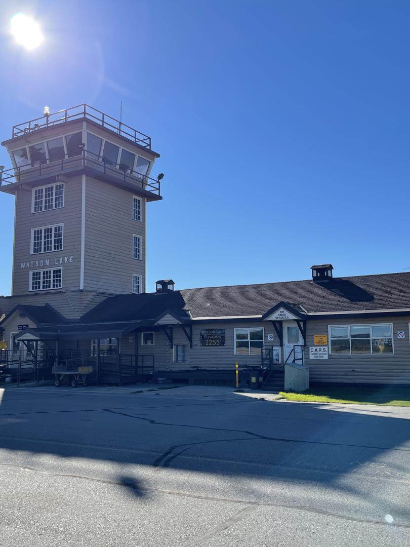 watson lake airport terminal under a blue, sunny sky