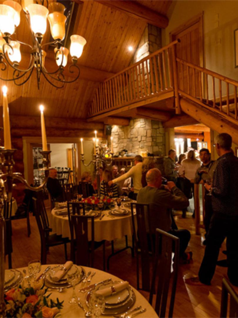 People gathering in the foyer of a wood cabin