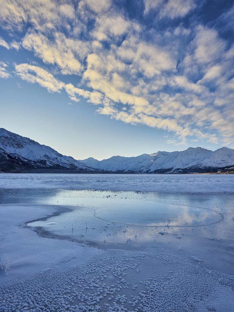 Frozen glacial river looking into a valley at sunset