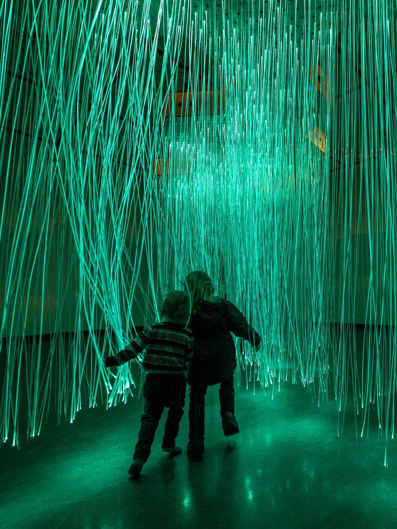 People walking through lights at an art exhibit