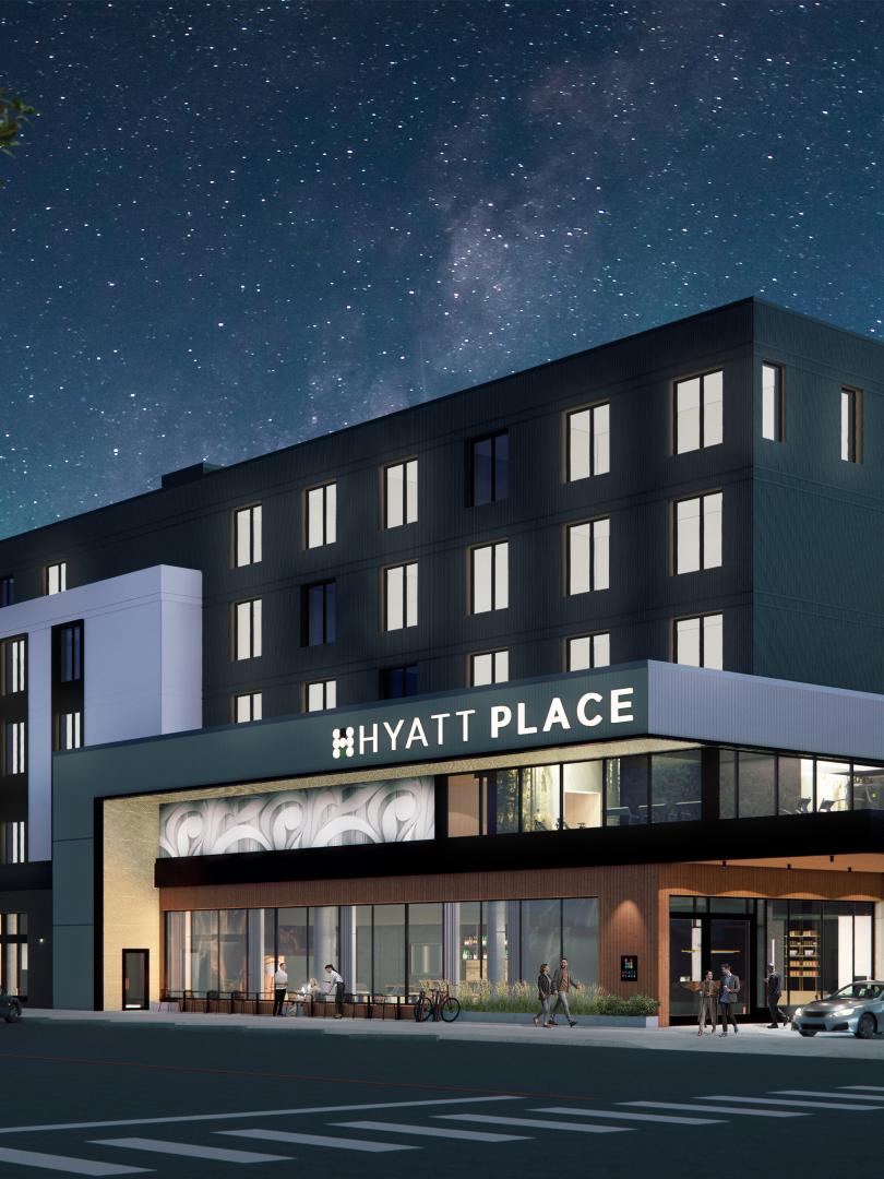Exterior of the Hyatt Place Whitehorse at night featuring lights on and twinkling stars.