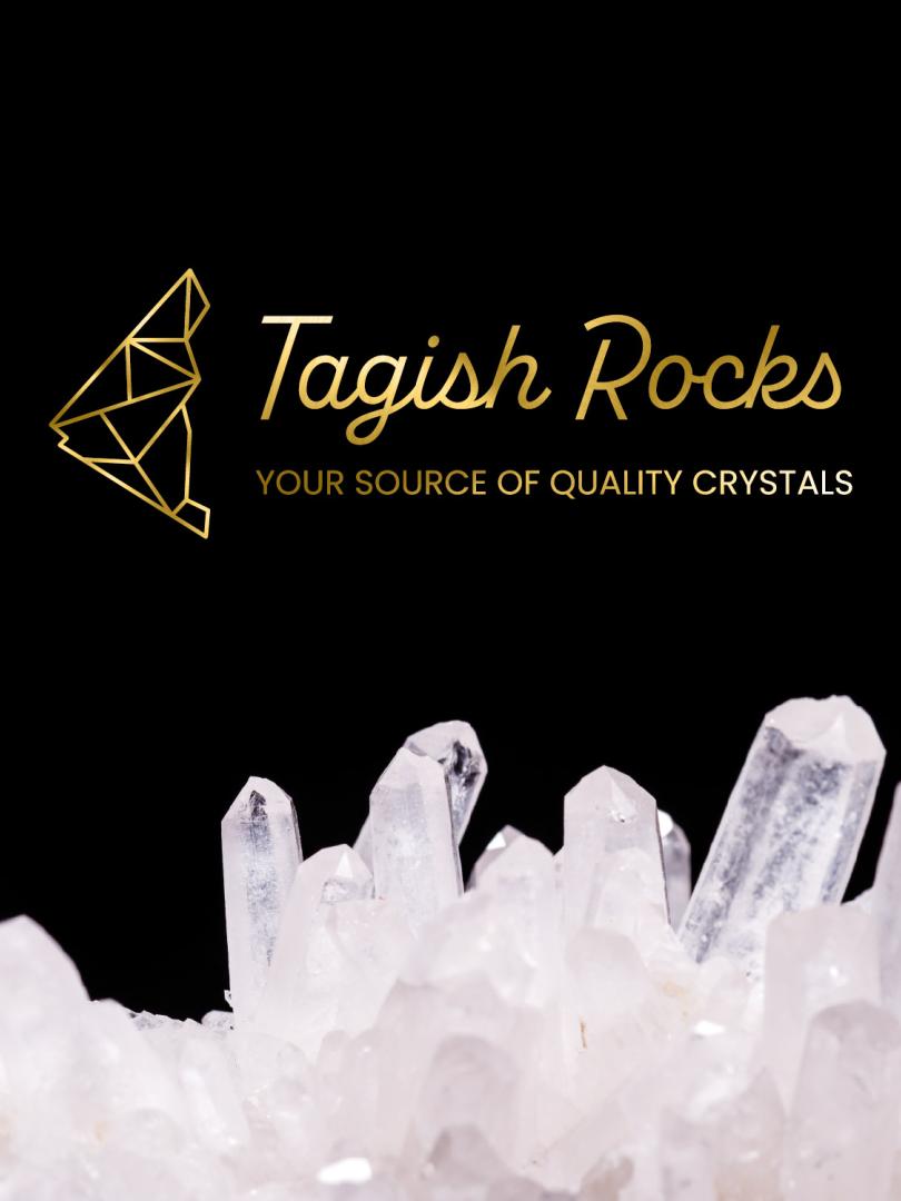Black background, gold Tagish Rocks logo with clear quartz lining the bottom