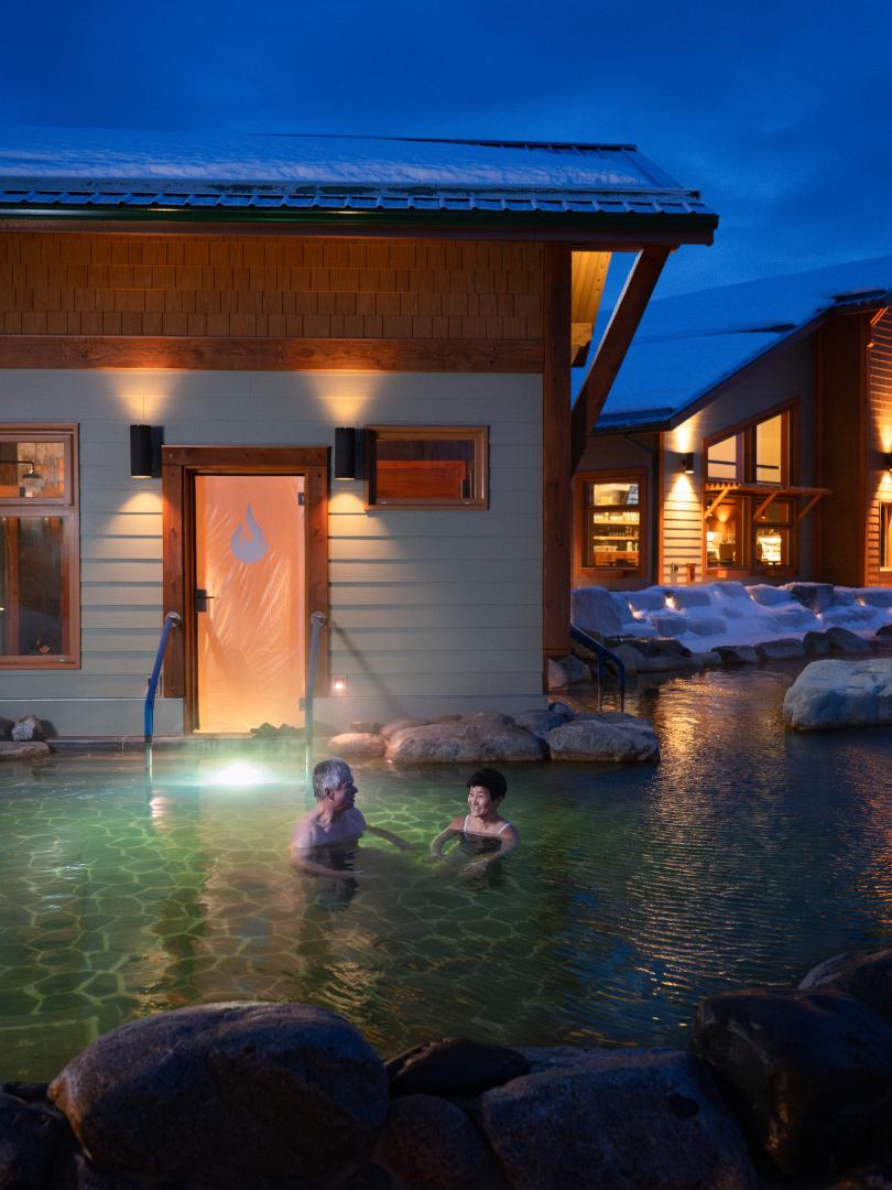 Two people enjoying hot springs in the winter