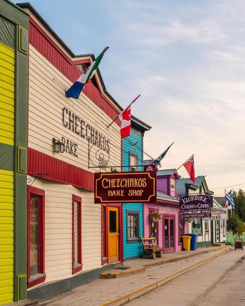 Colourful buildings are lined by an old wooden board walk