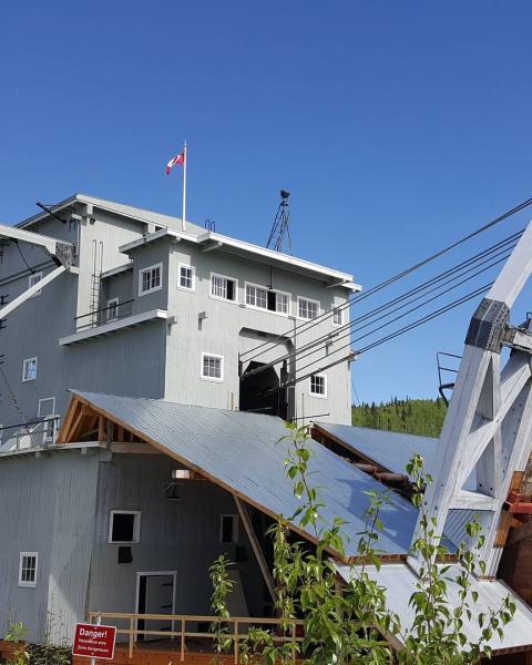 a bpale blue mining dredge under a blue sky