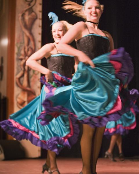 can can dancers in teal skirts dance on stage