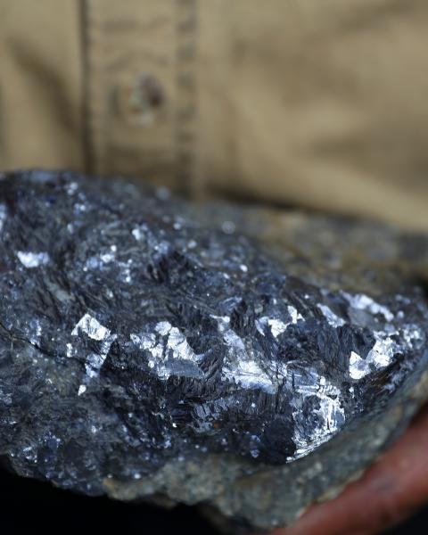 A lump of silver is held in someone's hands