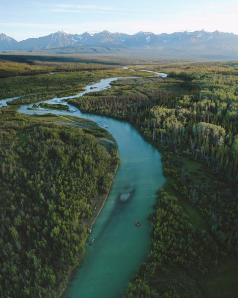 Aerial view of a raft on the Dezadeash River, with the Auriol Range in the distance.