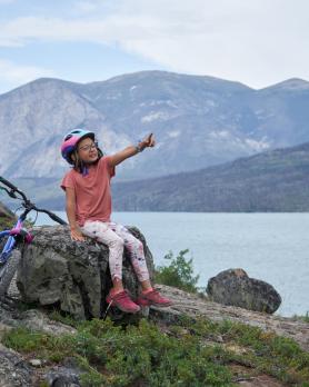 A child sits by the lake at Conrad Campground.