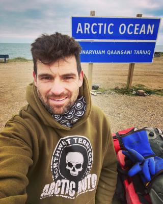 Rider arrives at the end of the Dempster in Tuktoyaktuk