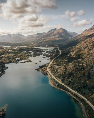 Road between lake and mountain