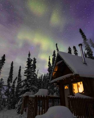 Evening winter scenery with a cabin and Aurora Borealis above