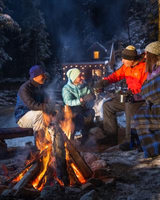 Group gathering around a fire with hot chocolate 