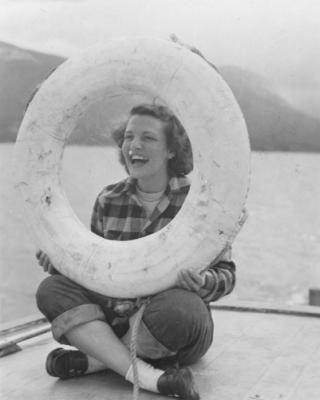 A historical photo of a woman holding a life preserve