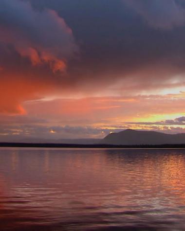 The midnight sun shines warmly over a Yukon lake