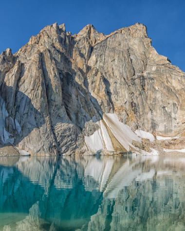 mountains above a crystal clear blue lake