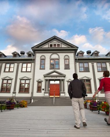 A group of people are walking up to the Dawson City museum