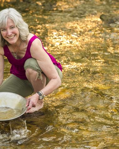A woman pans for gold in a Yukon creek