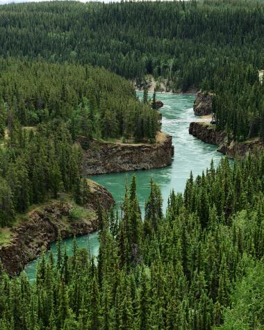teal water courses through cliffside canyons