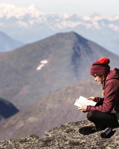 A hiker takes a relaxing break at the top of a mountain