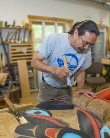 Yukon First Nation artist Keith Wolfe Smarch creating a carving
