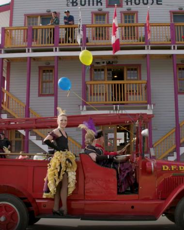 Can Can gilrs on a vintage truck in front of a Dawson City hotel