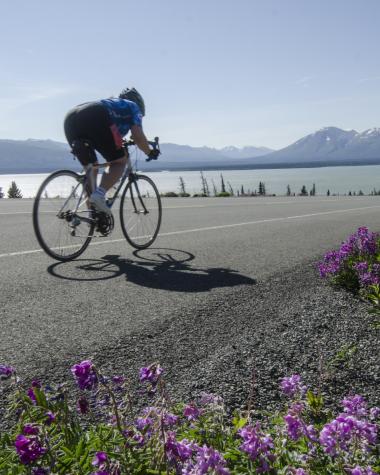 A road biker speeds down the side of a Yukon highway