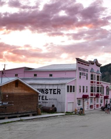 The sun sets over a main street in Dawson City