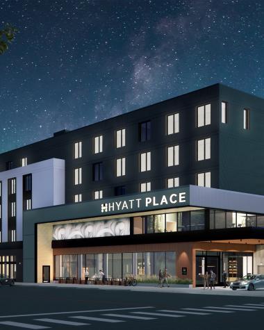 Exterior of the Hyatt Place Whitehorse at night featuring lights on and twinkling stars.