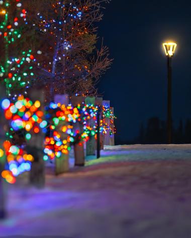 Two people embrance near Christmas lights