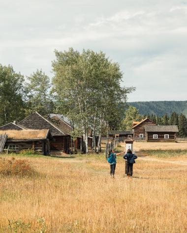 Two people walking at the site of Fort Selkirk
