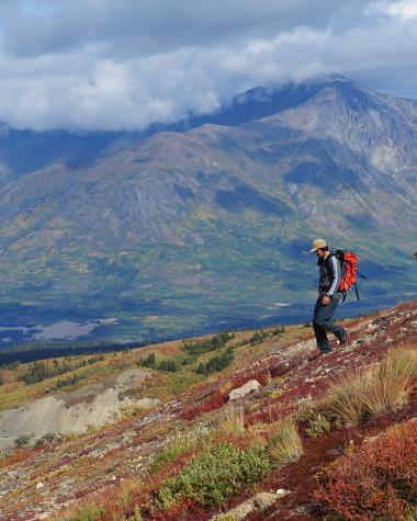 Two hikers descending among early fall colours
