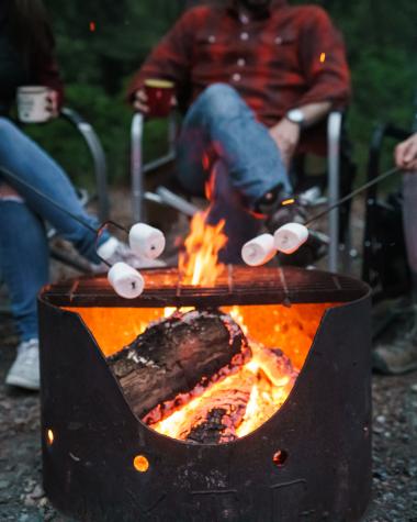 People roast marshmallows over a campfire